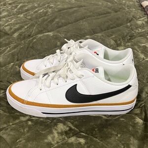Nike White Low-Top Sneakers with Black Swoosh and Gold Accent